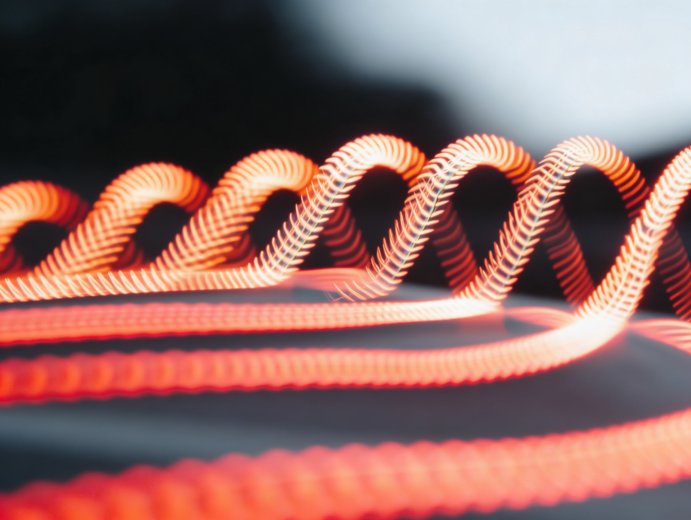 Abstract red light trails forming connected wave patterns, representing commercial integration, operational continuity and momentum carried through organisational change.